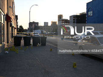 NYPD crime scene investigators place more than 28 evidence markers at the scene where a 27-year-old man is shot multiple times and killed in...