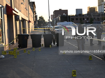 NYPD crime scene investigators place more than 28 evidence markers at the scene where a 27-year-old man is shot multiple times and killed in...