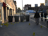 NYPD crime scene investigators place more than 28 evidence markers at the scene where a 27-year-old man is shot multiple times and killed in...