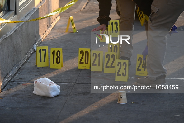 NYPD crime scene investigators place more than 28 evidence markers at the scene where a 27-year-old man is shot multiple times and killed in...