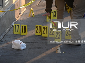 NYPD crime scene investigators place more than 28 evidence markers at the scene where a 27-year-old man is shot multiple times and killed in...