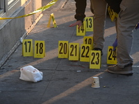 NYPD crime scene investigators place more than 28 evidence markers at the scene where a 27-year-old man is shot multiple times and killed in...