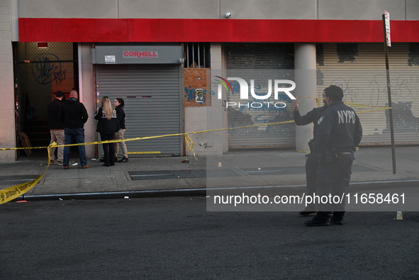 NYPD crime scene investigators place more than 28 evidence markers at the scene where a 27-year-old man is shot multiple times and killed in...