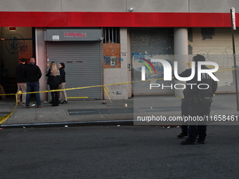 NYPD crime scene investigators place more than 28 evidence markers at the scene where a 27-year-old man is shot multiple times and killed in...