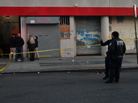 NYPD crime scene investigators place more than 28 evidence markers at the scene where a 27-year-old man is shot multiple times and killed in...