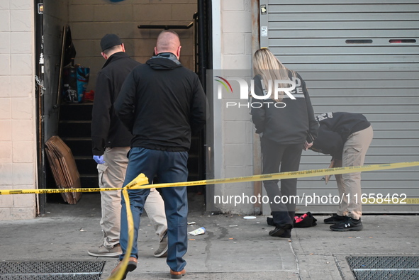 NYPD crime scene investigators place more than 28 evidence markers at the scene where a 27-year-old man is shot multiple times and killed in...