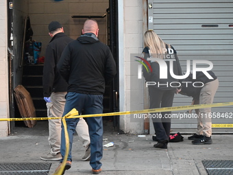 NYPD crime scene investigators place more than 28 evidence markers at the scene where a 27-year-old man is shot multiple times and killed in...