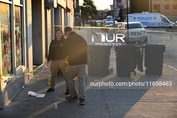 NYPD crime scene investigators place more than 28 evidence markers at the scene where a 27-year-old man is shot multiple times and killed in...