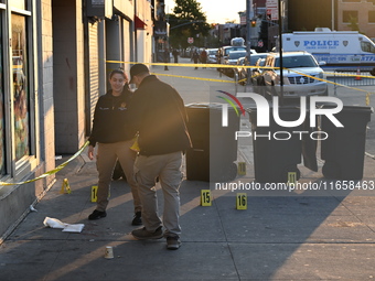 NYPD crime scene investigators place more than 28 evidence markers at the scene where a 27-year-old man is shot multiple times and killed in...