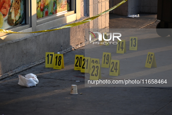 NYPD crime scene investigators place more than 28 evidence markers at the scene where a 27-year-old man is shot multiple times and killed in...