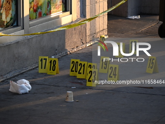 NYPD crime scene investigators place more than 28 evidence markers at the scene where a 27-year-old man is shot multiple times and killed in...