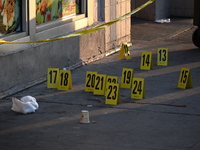 NYPD crime scene investigators place more than 28 evidence markers at the scene where a 27-year-old man is shot multiple times and killed in...