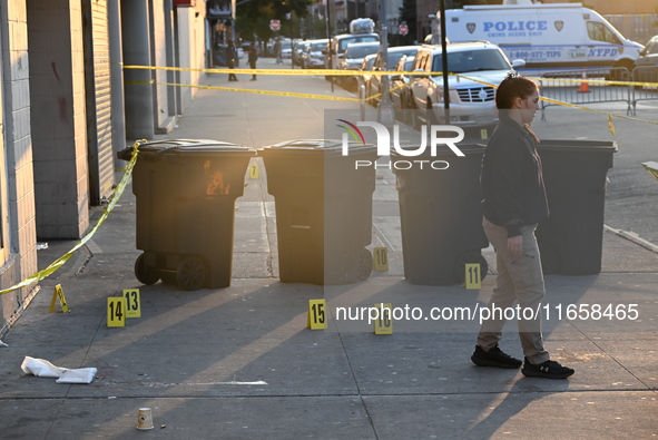 NYPD crime scene investigators place more than 28 evidence markers at the scene where a 27-year-old man is shot multiple times and killed in...