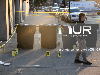 NYPD crime scene investigators place more than 28 evidence markers at the scene where a 27-year-old man is shot multiple times and killed in...