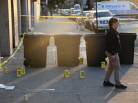 NYPD crime scene investigators place more than 28 evidence markers at the scene where a 27-year-old man is shot multiple times and killed in...