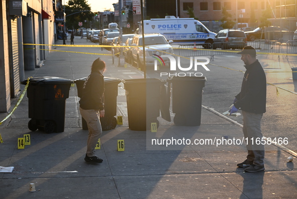 NYPD crime scene investigators place more than 28 evidence markers at the scene where a 27-year-old man is shot multiple times and killed in...