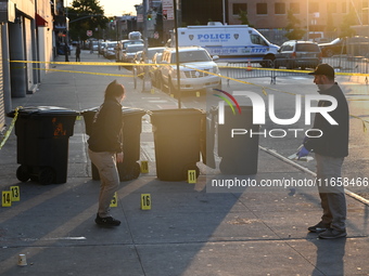 NYPD crime scene investigators place more than 28 evidence markers at the scene where a 27-year-old man is shot multiple times and killed in...