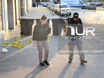 NYPD crime scene investigators place more than 28 evidence markers at the scene where a 27-year-old man is shot multiple times and killed in...