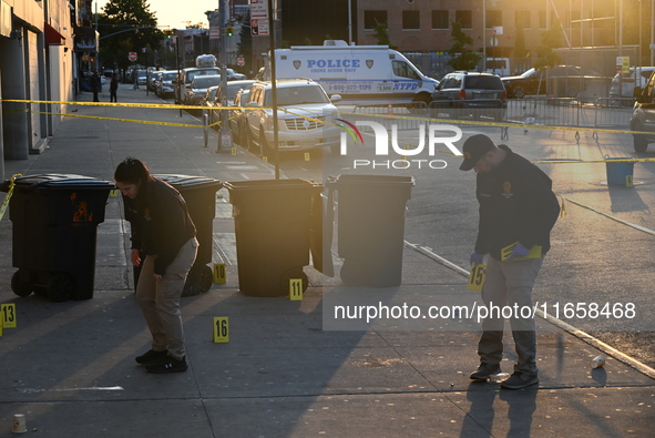 NYPD crime scene investigators place more than 28 evidence markers at the scene where a 27-year-old man is shot multiple times and killed in...