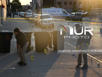 NYPD crime scene investigators place more than 28 evidence markers at the scene where a 27-year-old man is shot multiple times and killed in...