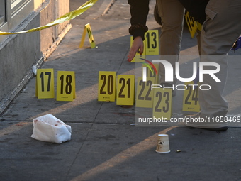 NYPD crime scene investigators place more than 28 evidence markers at the scene where a 27-year-old man is shot multiple times and killed in...