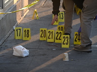 NYPD crime scene investigators place more than 28 evidence markers at the scene where a 27-year-old man is shot multiple times and killed in...