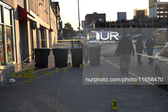 NYPD crime scene investigators place more than 28 evidence markers at the scene where a 27-year-old man is shot multiple times and killed in...