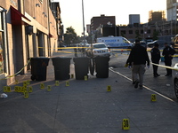 NYPD crime scene investigators place more than 28 evidence markers at the scene where a 27-year-old man is shot multiple times and killed in...