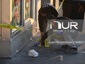 NYPD crime scene investigators place more than 28 evidence markers at the scene where a 27-year-old man is shot multiple times and killed in...