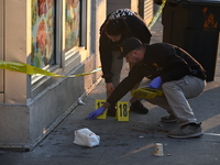 NYPD crime scene investigators place more than 28 evidence markers at the scene where a 27-year-old man is shot multiple times and killed in...