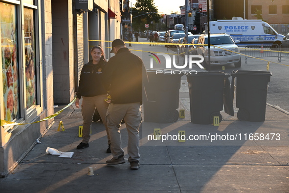 NYPD crime scene investigators place more than 28 evidence markers at the scene where a 27-year-old man is shot multiple times and killed in...