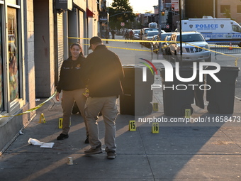 NYPD crime scene investigators place more than 28 evidence markers at the scene where a 27-year-old man is shot multiple times and killed in...