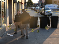 NYPD crime scene investigators place more than 28 evidence markers at the scene where a 27-year-old man is shot multiple times and killed in...