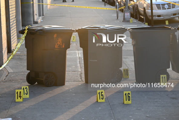 NYPD crime scene investigators place more than 28 evidence markers at the scene where a 27-year-old man is shot multiple times and killed in...