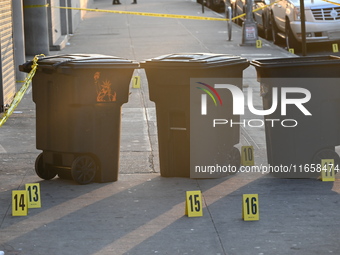 NYPD crime scene investigators place more than 28 evidence markers at the scene where a 27-year-old man is shot multiple times and killed in...