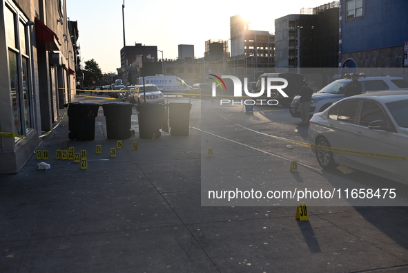 NYPD crime scene investigators place more than 28 evidence markers at the scene where a 27-year-old man is shot multiple times and killed in...