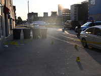 NYPD crime scene investigators place more than 28 evidence markers at the scene where a 27-year-old man is shot multiple times and killed in...