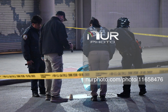 NYPD crime scene investigators place more than 28 evidence markers at the scene where a 27-year-old man is shot multiple times and killed in...