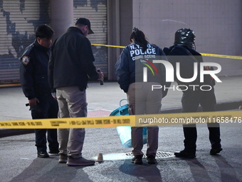 NYPD crime scene investigators place more than 28 evidence markers at the scene where a 27-year-old man is shot multiple times and killed in...