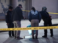 NYPD crime scene investigators place more than 28 evidence markers at the scene where a 27-year-old man is shot multiple times and killed in...