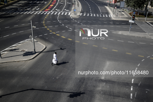 A person walks on a crosswalk on an empty street on Yom Kippur, the Jewish day of atonement and the holiest day in the Jewish calendar, amid...