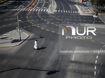 A person walks on a crosswalk on an empty street on Yom Kippur, the Jewish day of atonement and the holiest day in the Jewish calendar, amid...