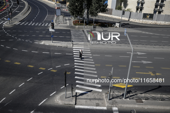 A person walks on a crosswalk on an empty street on Yom Kippur, the Jewish day of atonement and the holiest day in the Jewish calendar, amid...