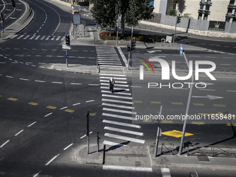 A person walks on a crosswalk on an empty street on Yom Kippur, the Jewish day of atonement and the holiest day in the Jewish calendar, amid...