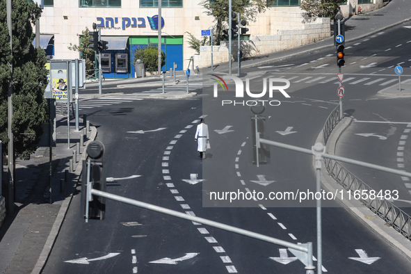 A person walks on a crosswalk on an empty street on Yom Kippur, the Jewish day of atonement and the holiest day in the Jewish calendar, amid...