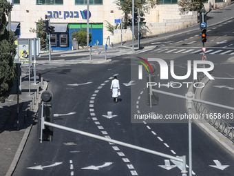 A person walks on a crosswalk on an empty street on Yom Kippur, the Jewish day of atonement and the holiest day in the Jewish calendar, amid...