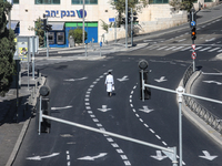 A person walks on a crosswalk on an empty street on Yom Kippur, the Jewish day of atonement and the holiest day in the Jewish calendar, amid...