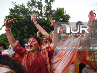 Indian Hindu devotees in traditional dress participate in the Hindu goddess Durga idol immersion in the River Ganges in Kolkata, India, on O...