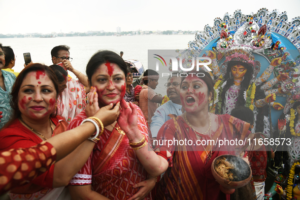 A married Hindu woman throws vermillion towards spectators during 'Sindoor Khela', a ritual during the Durga Puja festival in Kolkata, India...