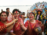 A married Hindu woman throws vermillion towards spectators during 'Sindoor Khela', a ritual during the Durga Puja festival in Kolkata, India...